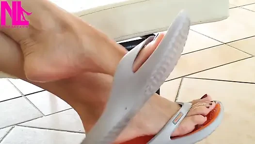 Cewek ini lagi asik goyang-goyang pakai sandal jepit oranye di kolam renang
