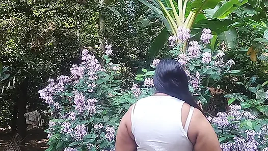 Schönes desi-mädchen macht sich draußen im garten nackt