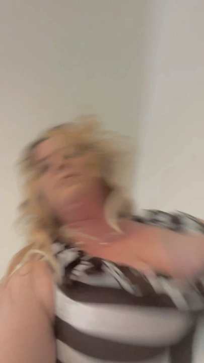 熟女弯下腰，在裙子上炫耀她的阴户。