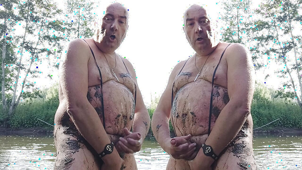 The plump, mustachioed daddy is having a blast in the stream, shamelessly masturbating with mud