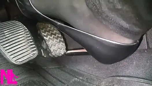 Pedal memompa dengan stoking hitam dan sepatu hak tinggi paten abu-abu