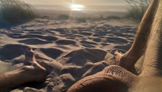 Playa al atardecer masturbándose