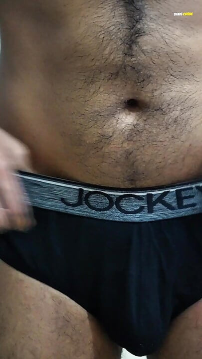 Young man wearing black underwear is dancing cock while holding his groin area.