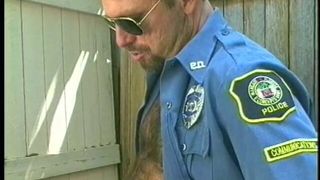 Muscular man in uniform and wearing glasses sucks and blows