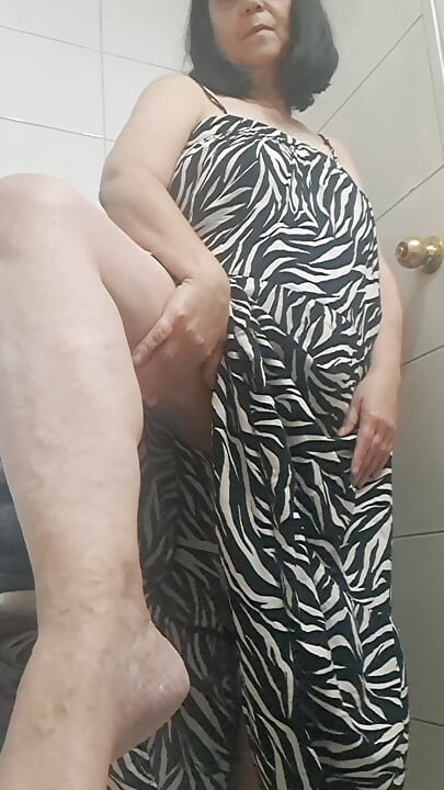 in the bathroom showing what's under her dress to her young lover on camera