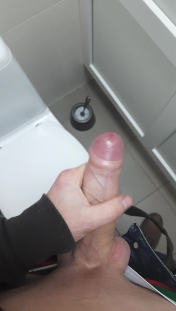 Jerking off a cock in the toilet at work