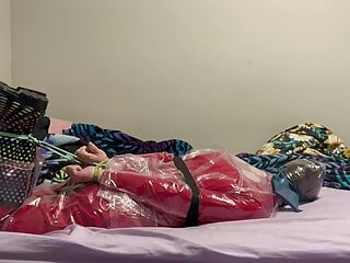 Bondage em traje de chuva transparente e macacão de pvc vermelho