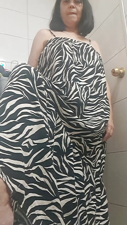 in the bathroom showing what's under her dress to her young lover on camera