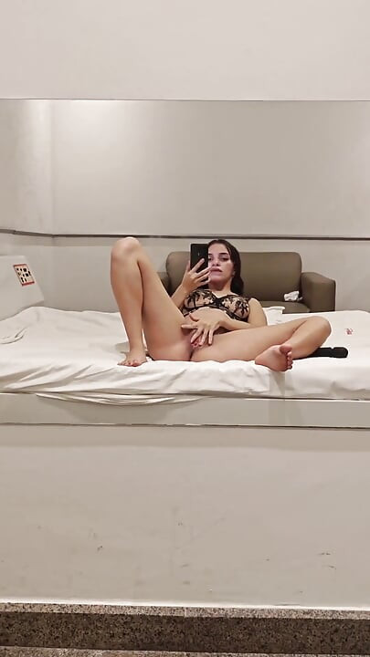 Brunette met kort haar gebruikt haar vibrator voor een motelspiegel