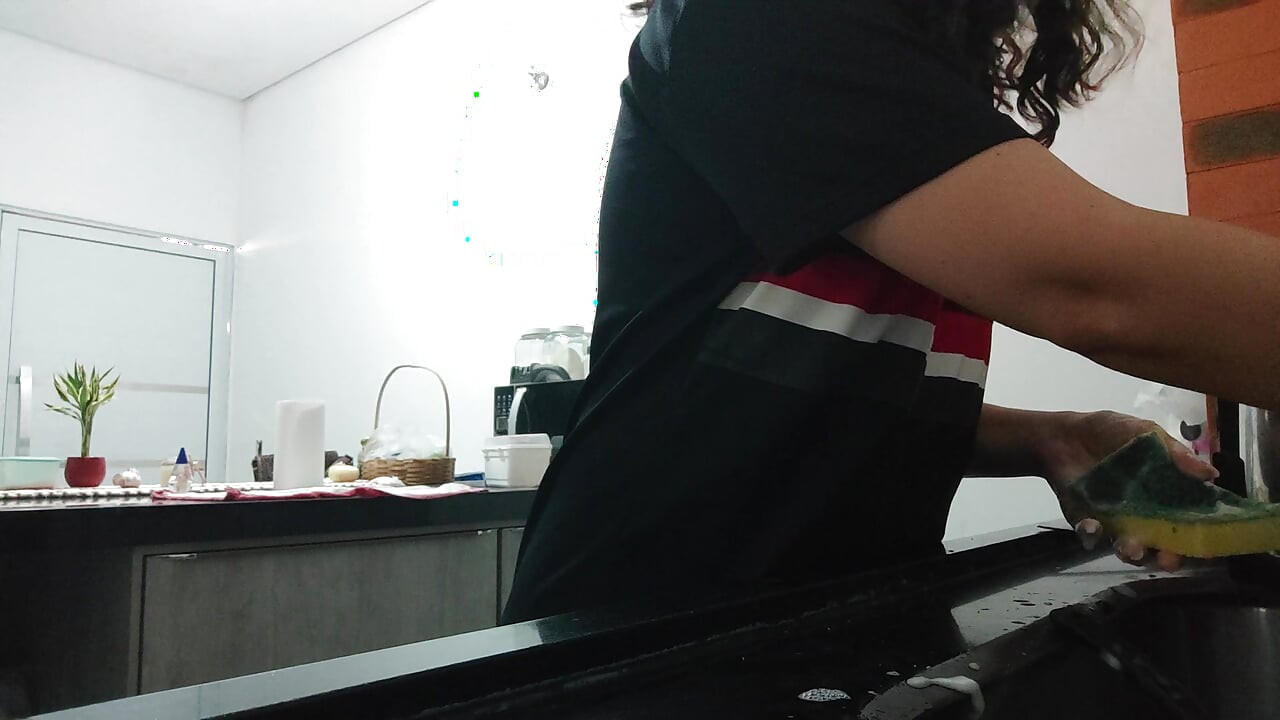 Woman teasing while washing dishes. She loves to transmit to the voyeurs on duty