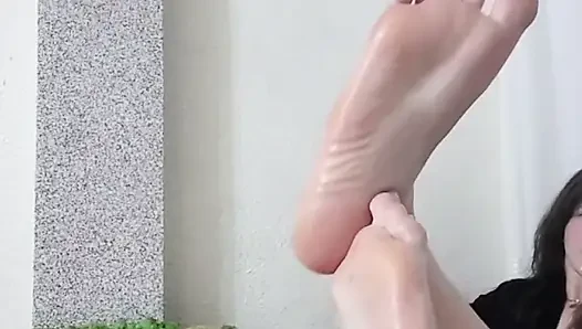 Girl showing beautiful feet, legs in oil
