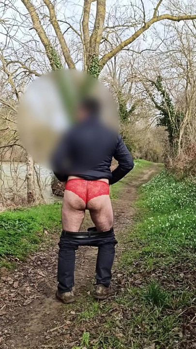 Açık havada kırmızı külotlu bir adamın striptizi