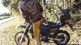 Punkbiker in gold leggings on his Suzuki DR650 Dakar