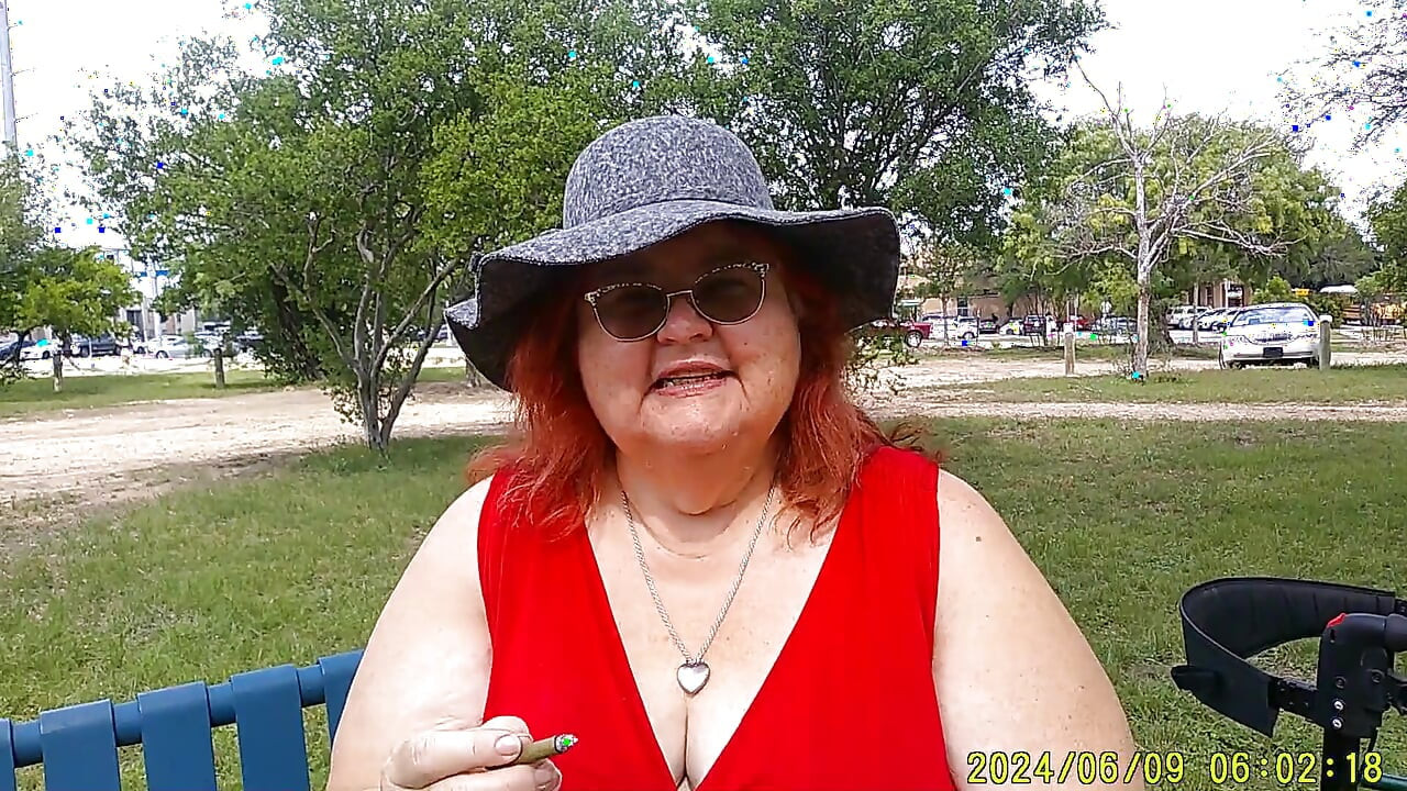 Hemşire Vicki parkta bankta tamamen giyinmiş sigara içiyor