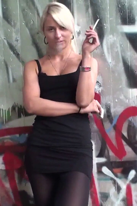 Lovely blonde teen smoking a cigarette outdoors