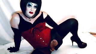Сисси Drag Queen в тяжелом макияже играет с батплагом, из задницы в рот