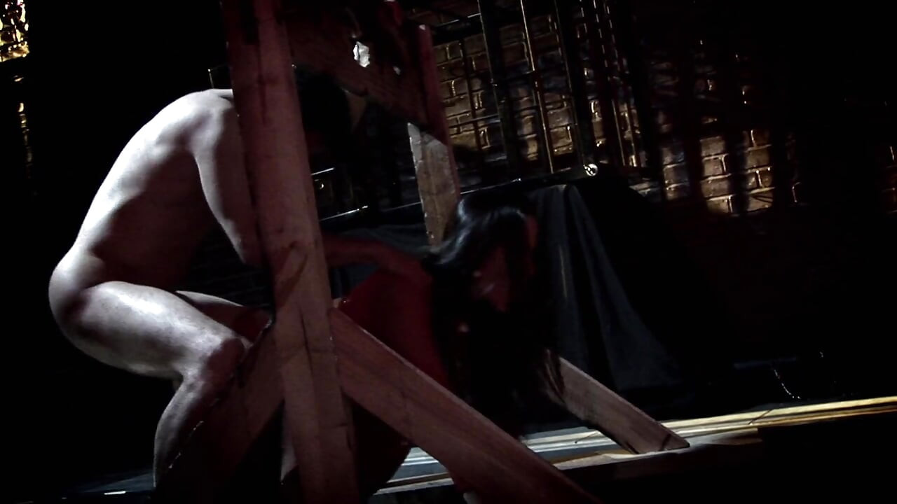 Busty milf in leather and fishnets seduces man in the dungeon