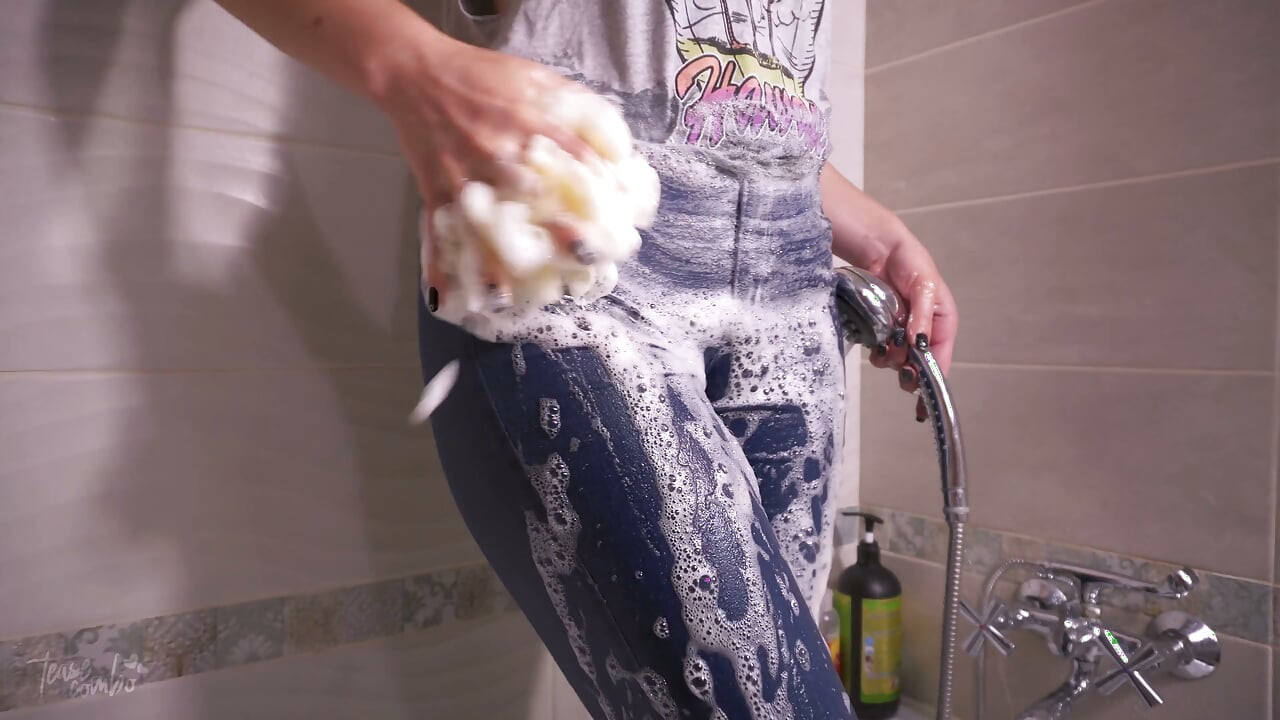 Une fille taquine un camel toe mouillé en jean bleu
