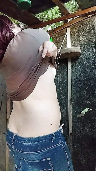 I'm watching a curvy girl wash herself in the street.