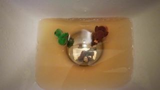Two little toy figures get a shower of piss
