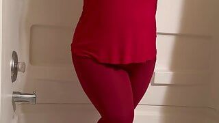 Ragazza calda è disperata per fare pipì in pantaloni da yoga rossi attillati