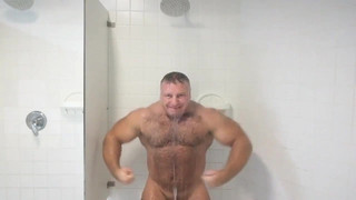 bodybuilder andre mark flexing in shower