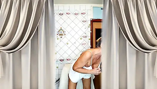 Real home solo of a mature woman in a small cozy kitchen.