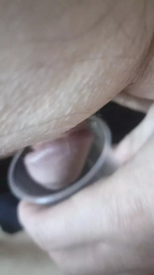 Jerking dick for cum in plastic cup.