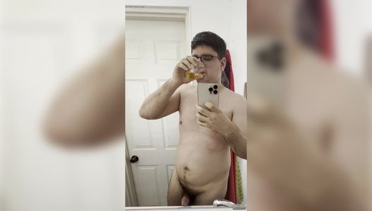 21-jähriger junge pinkelt in eine transparente tasse und trinkt all seine eigene pisse