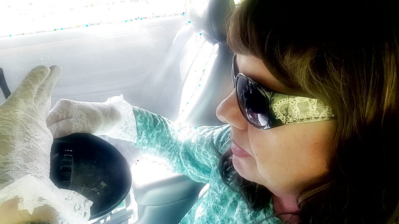 ローマン・ホルダー夫人が白いレースの手袋とサングラスをかけてVS120を吸っている