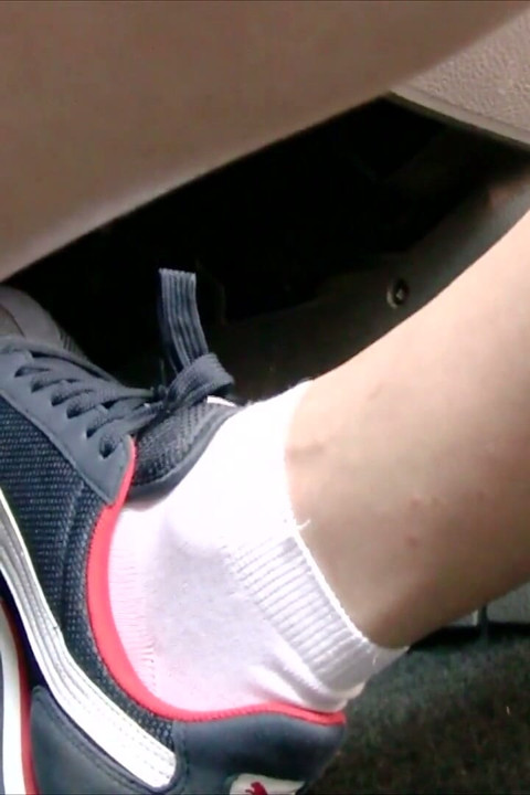 青いナイキのスニーカーと白い靴下で運転する