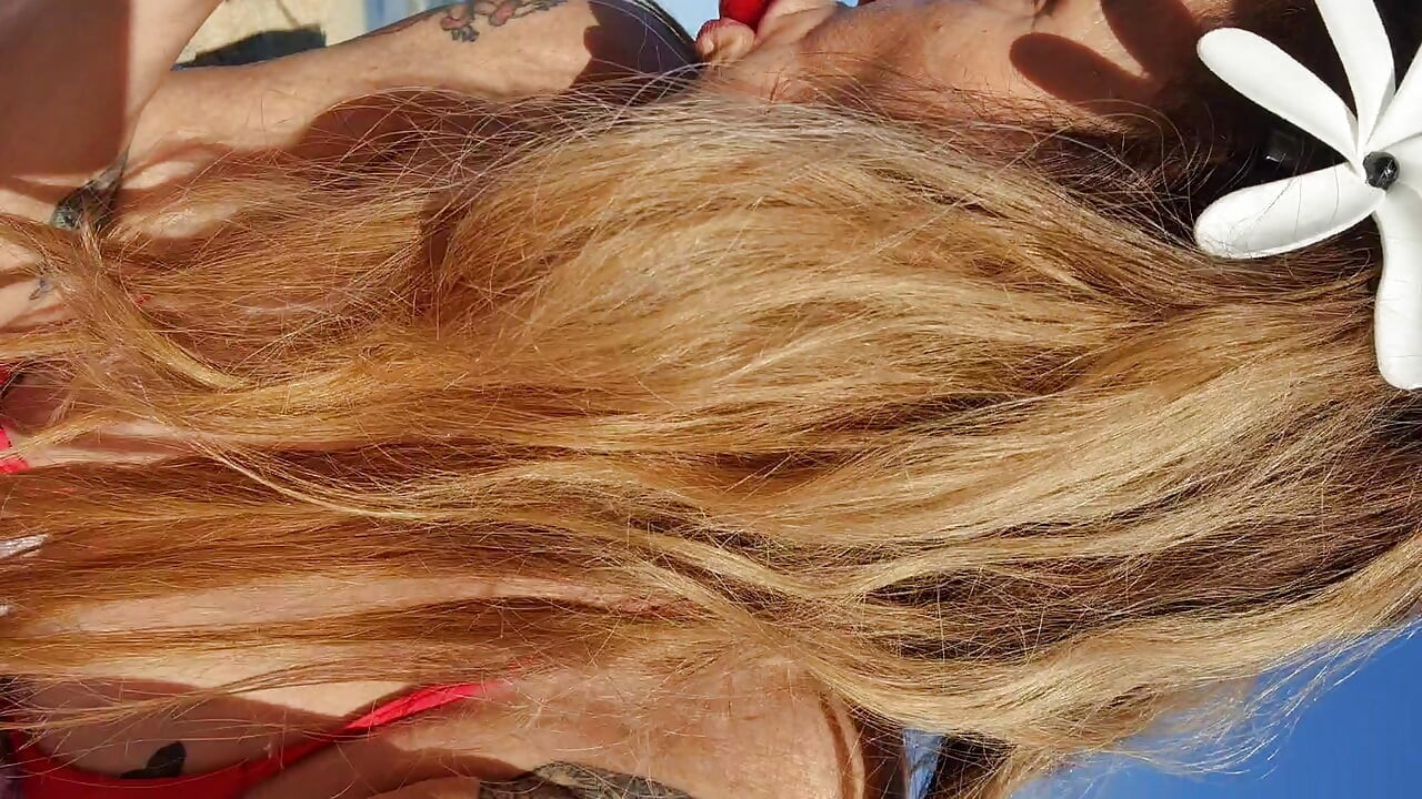 Melissa Johnson sucks and licks a cherry lollipop on the .beach