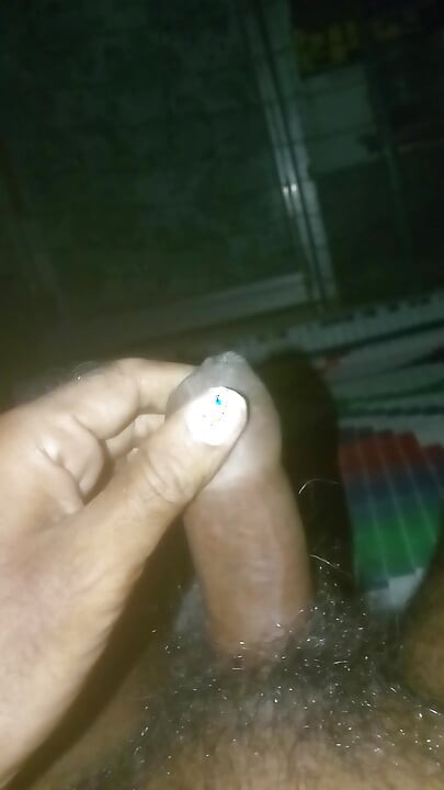 Balançando o Pau com a mão trabalhando à noite na cama.