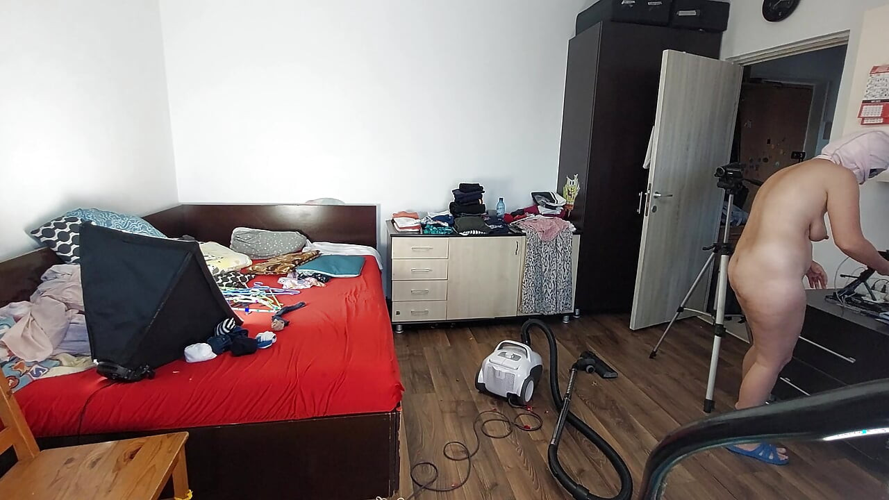 An amateur woman cleans the house with the vacuum cleaner. Sexy mom has fun with naked roses