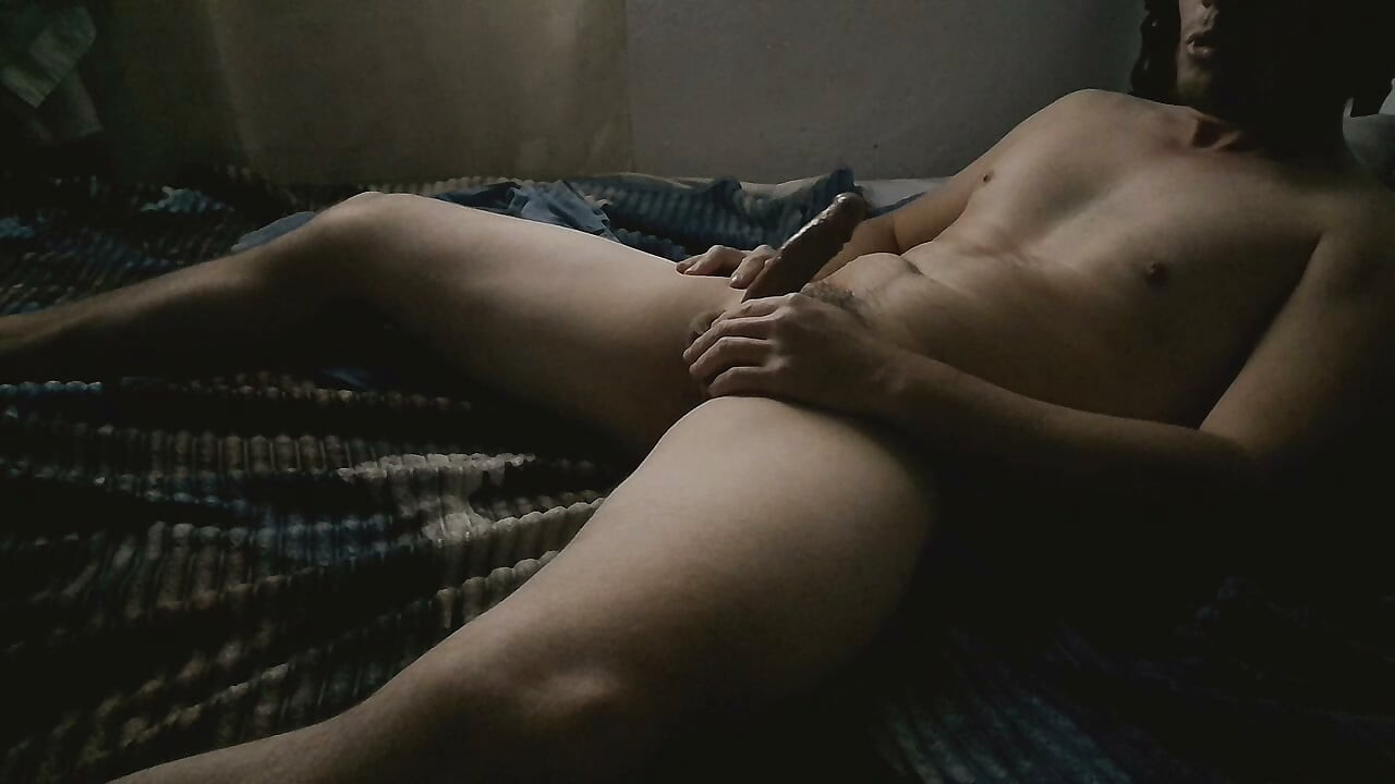 A solitary man in his room masturbates intensely, building up to a powerful orgasm.