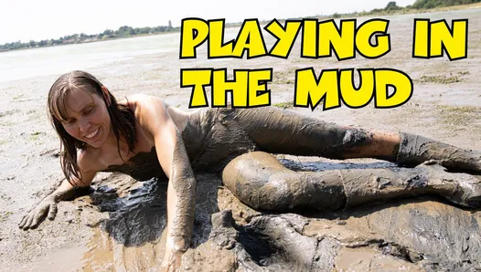 Обнаженная девушка играет в грязи
