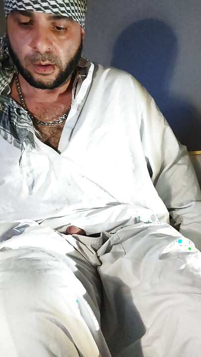 Брудний джанкбро, одягнений в афганський одяг, пісяють у шкарпетках і п'ють