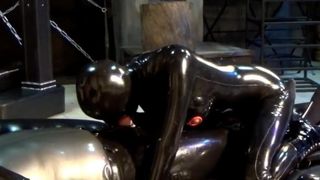 couple in black latex catsuit mask and the blowjob girl