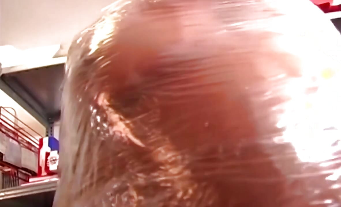Plastikindpakket tøs, der gaber bredt gennem skinnende film