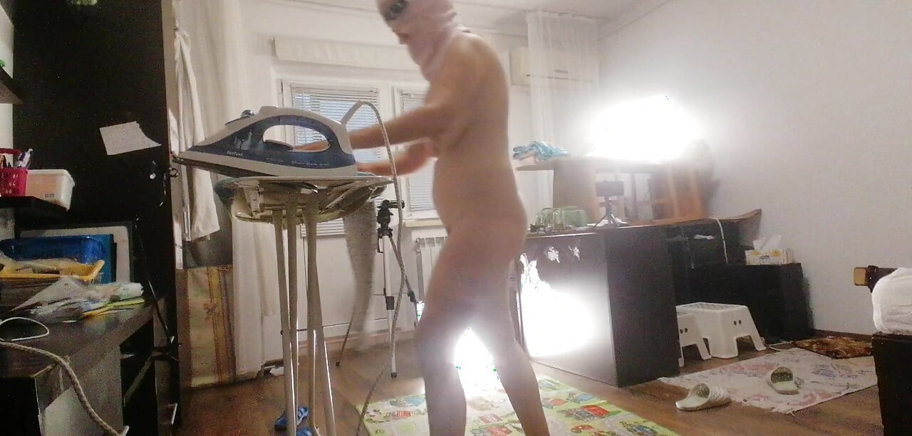 Sexy brunette doing naked chores around the house