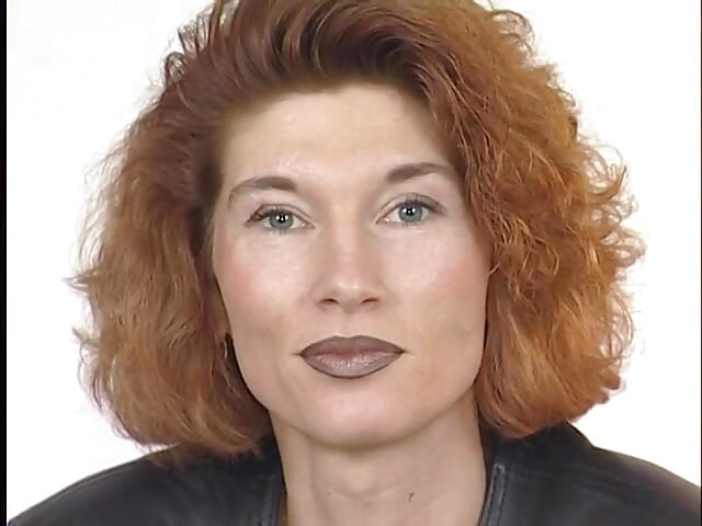 Tattooed ginger milf is filling her pussy with a big dildo