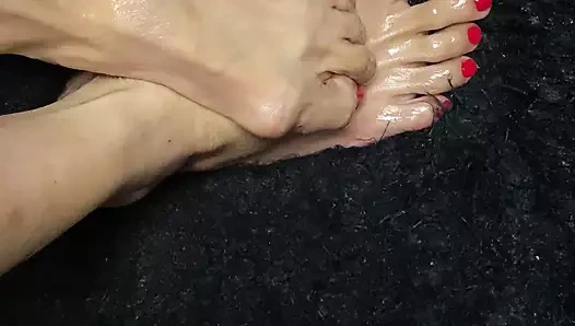 Oiled sexy tiny feet with red toenail polish