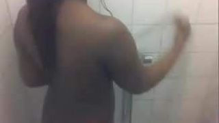 O fată neagră face un duș