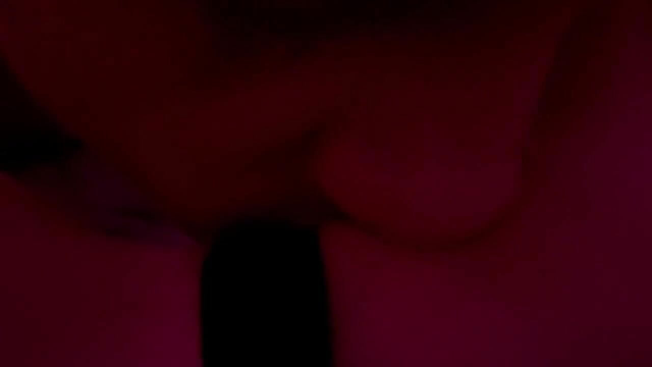 Pareja real en momento íntimo bajo luces rojas