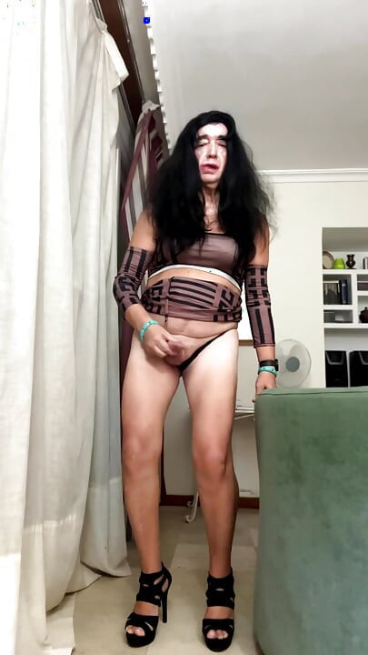 Une belle trans espagnole sexy pose et se masturbe dans le salon avec une minijupe moulante et des talons hauts, anal