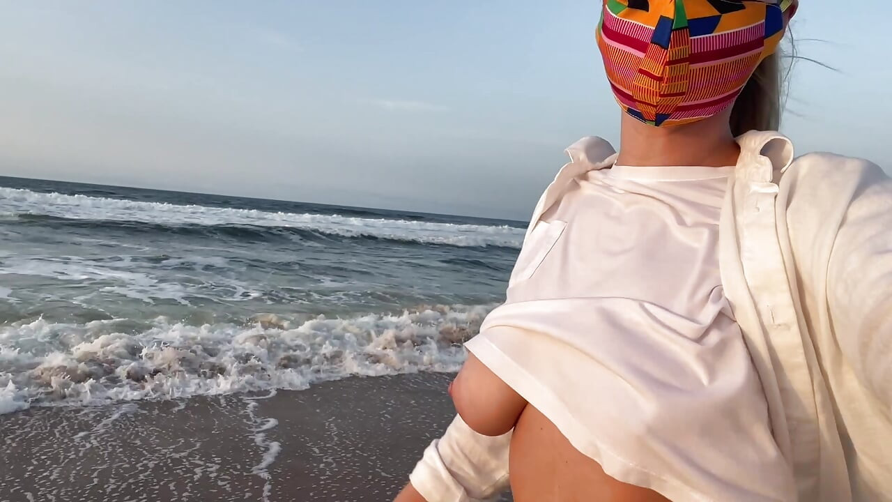 Blondine mit großen Brüsten ohne BH läuft die Straße entlang