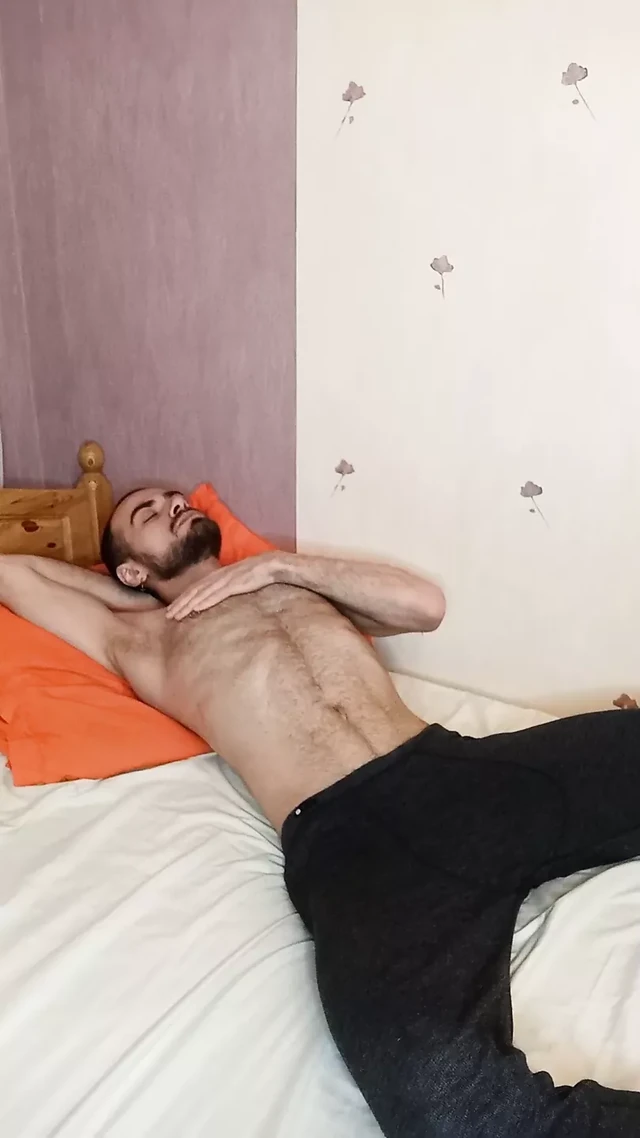 A guy masturbates lying in bed on camera