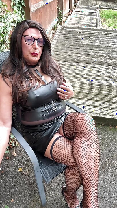 Seksi transvestit kellycd2022 u crnom PVC bodiju i mrežastim čarapama i štiklama
