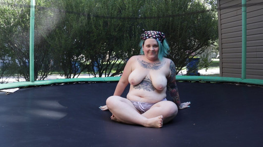 Milf gorda tatuada saltando y desnudándose en un trampolín