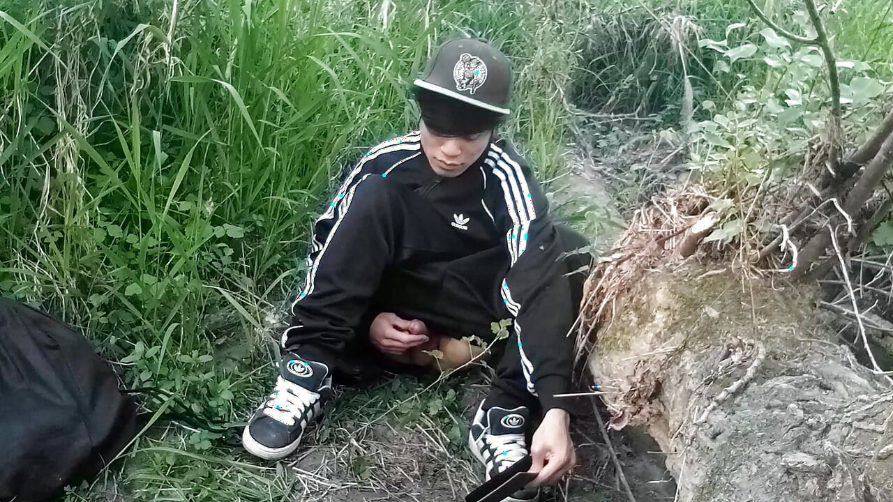 Cute Asian gay twink in a black-and-white adidas tracksuit and Campus sneakers masturbates and cums outdoors